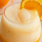 Refreshing morir sonando in a glass, garnished with orange slice.